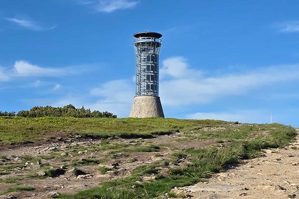 Nowoczesna, stalowo-szklana wieża widokowa na szczycie Śnieżnika w słoneczny dzień