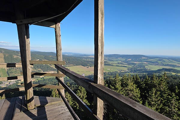 Krajobraz pasm górskich obserwowany z drewnianego tarasu Trójmorskiego Wierchu w Masywie Śnieżnika